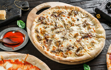 Wall Mural - Pizza with chicken meat, mushrooms, cheese, onion, sauce on dark wooden background. Fast food lunch for picnic company, close up, selective focus