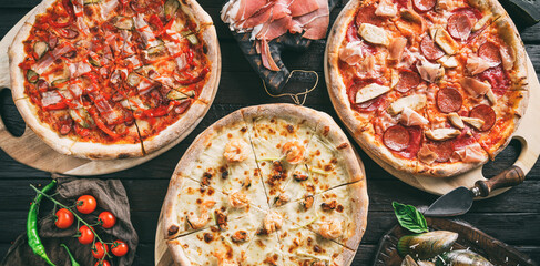 Canvas Print - Variety of meat pizzas with sausage, ham, prosciutto, salami, chicken fillet, pepperoni, shrimps, cheese, greens, vegetables on dark background. Fast food lunch for picnic company, top view, toning