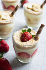 Magnolia dessert with fresh bananas and strawberries in glass cup, homemade milky dessert concept