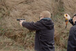 © Air_Lady - Man fires automatic handgun pistol during training in practical shooting. Man with gun, gangster. Blur crazy young man aiming automatic gun at target. 25 April 2021, Ryazan, Russia