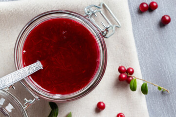 Wall Mural - Glass jar with homemade lingonberry sauce. Canning lingonberry sauce, top view, flat lay