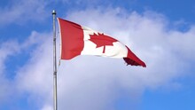 Canadian Maple Leaf Flag Blowing In The Wind With Blue Sky And Clouds