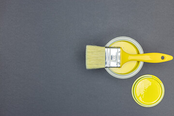 Wall Mural - open can of paint with paintbrush on it on grey background. top view flat lay.