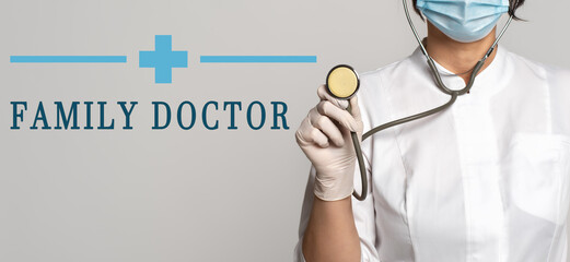 Wall Mural - FAMILY DOCTOR - concept of text on gray background. Nearby is a cropped view of doctor with stethoscope