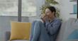 © stokkete - Woman sitting on the couch and drinking a tea