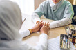© Art_Photo - Muslim asian woman doctor service help support discussing and consulting talk to muslim woman patient and holding hand at meeting health medical care express trust concept in hospital.healthcare