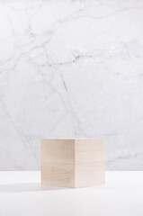 Wall Mural - Wooden cube as podium on white wood board and grey plaster wall, showcase for cosmetics product display, vertical.