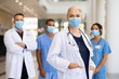 © Rido - Satisfied doctor with medical staff looking at camera