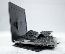 The Laptop Is Smashed To Pieces. The Screen Is Cracked, The Keyboard Is Broken. Electro Waste.