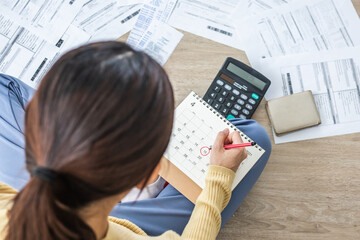 Wall Mural - Top view owe, mortgage asian woman, female sitting on floor home, stressed calculate expense from bills, no money pay in mark circle deadline on calendar.Debt, bankruptcy or bankrupt person concept.