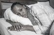 © TheVisualsYouNeed - young African American girl at night suffering depression and insomnia - attractive sad and depressed black woman lying thoughtful and depressed on bed sleepless