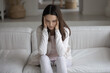 © fizkes - Depressed teen girl trying to cope with stress, anxiety and panic attack at home. Tired exhausted millennial woman suffering from headache, feeling fatigue, burnout, holding head with closed eyes
