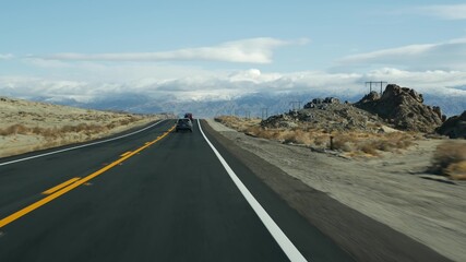 Road trip to Death Valley, driving auto in California, USA. Hitchhiking traveling in America. Highway, mountains and dry desert, arid climate wilderness. Passenger POV from car. Journey to Nevada.