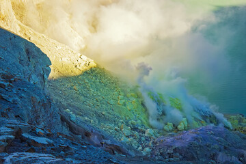 Wall Mural - Gas coming out of the sulphur mines in the crater on the bottom of Mount Kawah Ijen active volcano, Banyuwangi, East Java, Indonesia. 