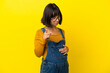 © luismolinero - Young pregnant woman over isolated yellow background frustrated and pointing to the front