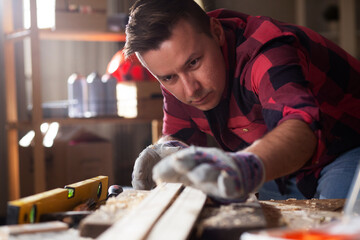 Wall Mural - Young male carpenter working in workshop. Carpenter working on wood craft at workshop.