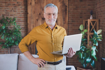 Sticker - Photo of positive candid aged person hold laptop put hand on waist beaming smile look camera have good mood indoors