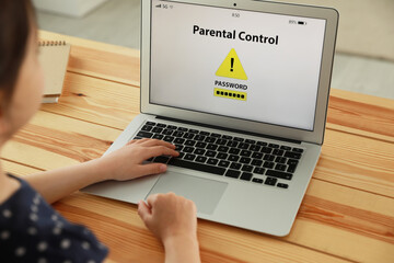 Child using laptop with installed parental control app at home, closeup. Cyber safety