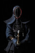 Japanese kendo fighter with with shinai on a black background