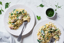 Spaghetti Pasta With Tuna, Spinach And Creamy Sauce On White Plate With Fresh Herbs, White Marble Background.