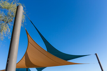 Two sun shade canopies against a clear blue sky used in the Southwest to block the desert sun