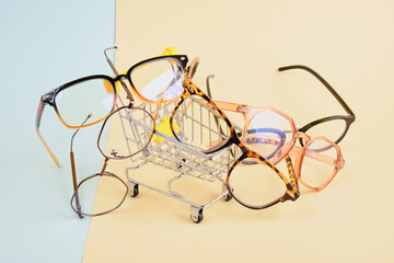 several fashionable trendy eyes glasses for correcting vision on a colorful background, a geometric background from pastel paper