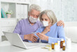 © aletia2011 - ill senior couple with facial masks using laptop