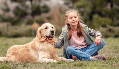 Wall Mural - Little girl with golden retriever dog outside