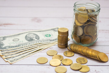 money saving or financial and banking for business investment concept. bank note us dollar with piggy bank and coin in glass jar and calculator on wood table.