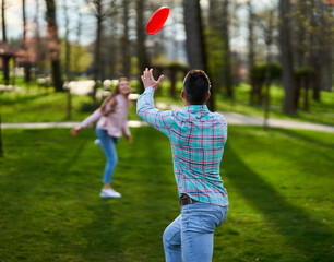 Young couple playing freesbie in the park