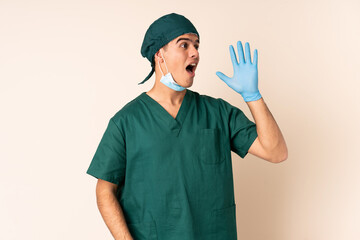 Wall Mural - Surgeon man in blue uniform over isolated background shouting with mouth wide open