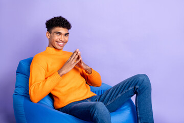 Sticker - Profile side photo of charismatic afro american young guy sit bean bag smile isolated on purple color background