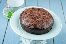 Traditional Austrian Sacher Chocolate Cake With Crumbles Served As Close-up On An Ceramic Cake Plate
