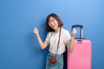 Portrait of young female traveler isolated over purple background studio.