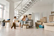 © insta_photos - Happy family couple new home owners buyers relaxing on couch with kid child son playing around boxes on moving day in living room. Relocation and house renovation, estate property purchase, removal.