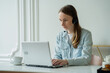 © Grustock - Female talking in a video conference on line with a headset with microphone and using laptop in office, consulting client