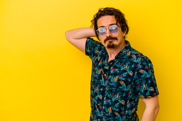 Young caucasian man wearing summer clothes isolated on yellow background touching back of head, thinking and making a choice.