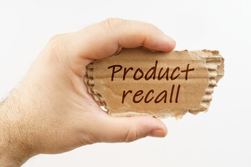 A man holds a cardboard in his hand on which it is written - Product recall