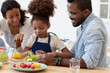 © fizkes - Happy family couple and daughter girl preparing salad in kitchen for keeping healthy eating lifestyle. Kid learning from mom and dad to cook organic vegetarian meal, cutting fresh vegetables