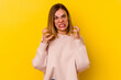 © Asier - Young caucasian skinny woman isolated on yellow background upset screaming with tense hands.
