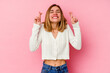 © Asier - Young caucasian woman isolated on pink background crossing fingers for having luck