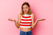 © Asier - Young caucasian woman isolated on pink background holding something with palms, offering to camera.