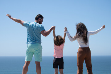 Wall Mural - Happy family on the beach. People having fun on summer vacation. Father, mother and child on blue sea. Carefree family concept.