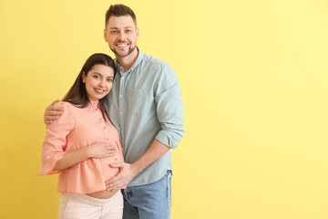 Wall Mural - Beautiful pregnant couple on color background