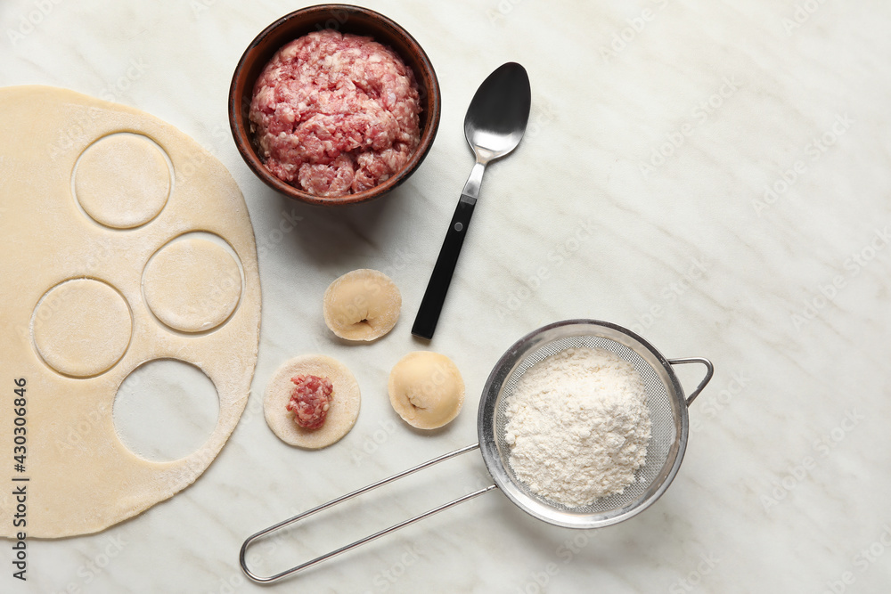 Preparing of tasty dumplings on light background