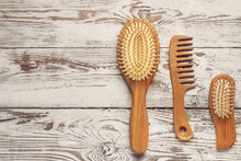 Hair Comb And Brushes On White Wooden Background