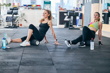 Two women using foam rollers during the workout