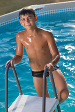 Teen Boy Smiling Coming Out Of The Pool On The Stairs, Top View