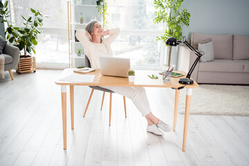 Sticker - Full length photo of attractive nice young woman hold hands behind head relax sit desk indoors inside house home