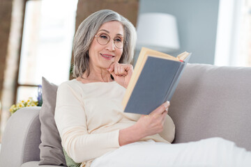 Sticker - Portrait of attractive focused cheery woman lying on divan enjoying reading interesting book pastime at home house flat indoor